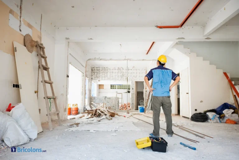 Un artisan devant son chantier de rénovation d'une maison.